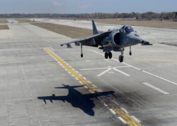 A Harrier jet landing at an airfield.
