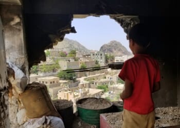 Child and ruined house in Yemen.