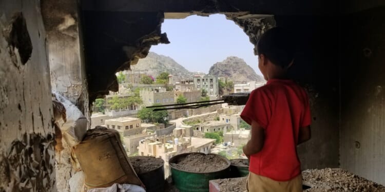 Child and ruined house in Yemen.