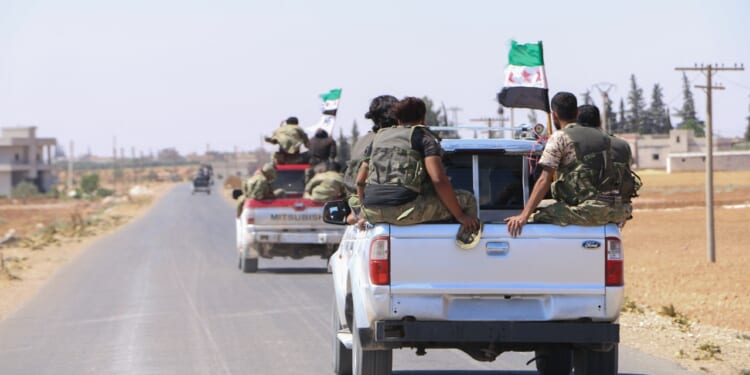 A group of Syrian rebels in a pickup truck.