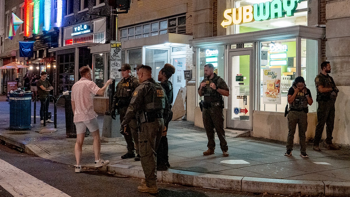 Federal officers speaking with Sean Dunn on the street at night