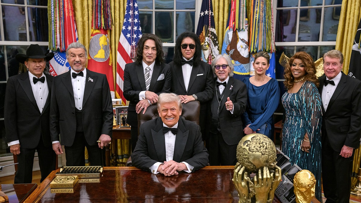 President Donald Trump at the Resolute Desk with 2025 Kennedy Center Honorees