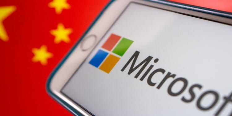 Kumamoto, JAPAN - Mar 10 2021 : Concept image Microsoft logo on iPhone with Chinese flag background. Cyberattack, IT technology risk and conflict concept