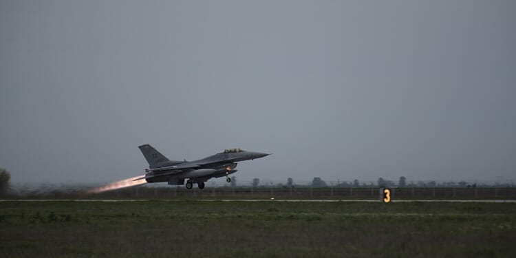 An F-16 Fighting Falcon taking off from a runway.