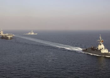 A Spanish F-100 frigate at sail near American aircraft carriers.