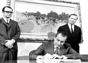 View of President Richard Nixon signing the Clean Air Act of 1970 at the White House. Looking on are William Ruckelshaus, Administrator of the Environmental Protection Agency (left), and Russell E. Train, Chairman of the Council on Environmental Quality.