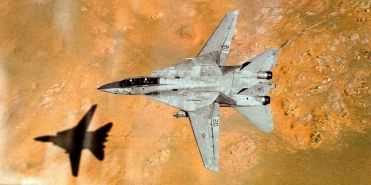 An F-14 Tomcat in flight over a desert.