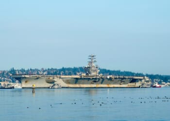 A side view of the USS Nimitz, with notable rust.