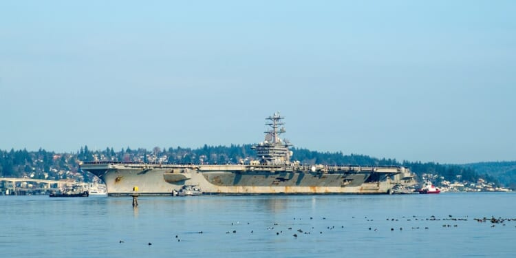 A side view of the USS Nimitz, with notable rust.