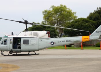 A Bell UH-1 "Huey" helicopter at an airfield.