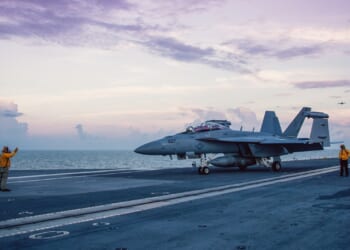 A fighter jet on an aircraft carrier deck.