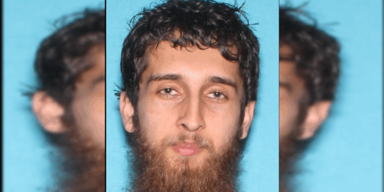 Image of a man with a beard and short, curly hair against a blue background, typically used for identification purposes.