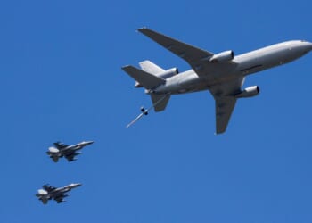 Two fighter jets conduct aerial refueling with a tanker.