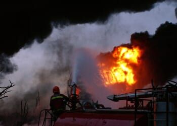 A firefighter fighting an oil fire.