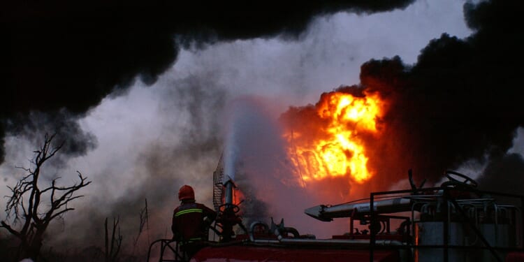 A firefighter fighting an oil fire.