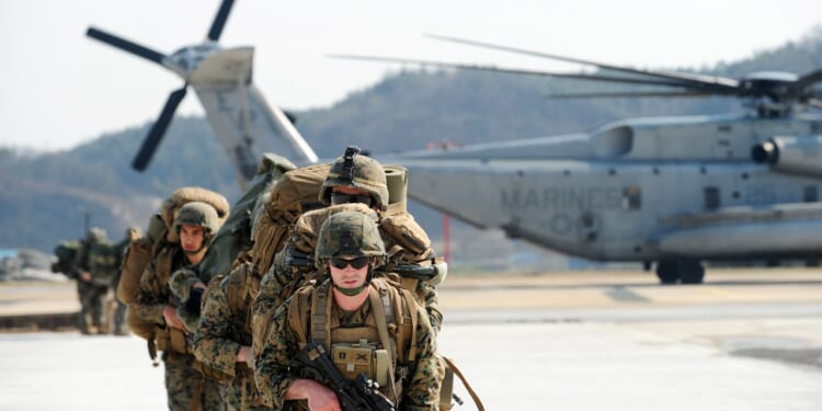 A group of US Marines leaving a helicopter.