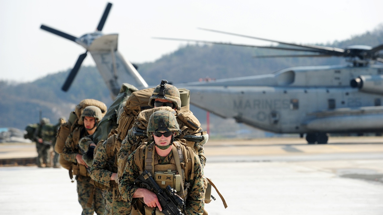 A group of US Marines leaving a helicopter.