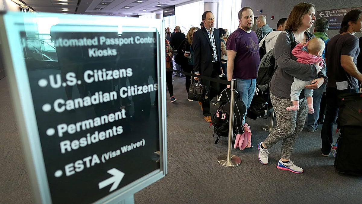 People line up at U.S. passport control inside airport