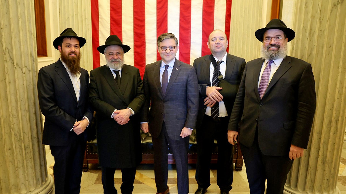 Mike Johnson poses with Ahmed Al-Ahmed and three Jewish leaders