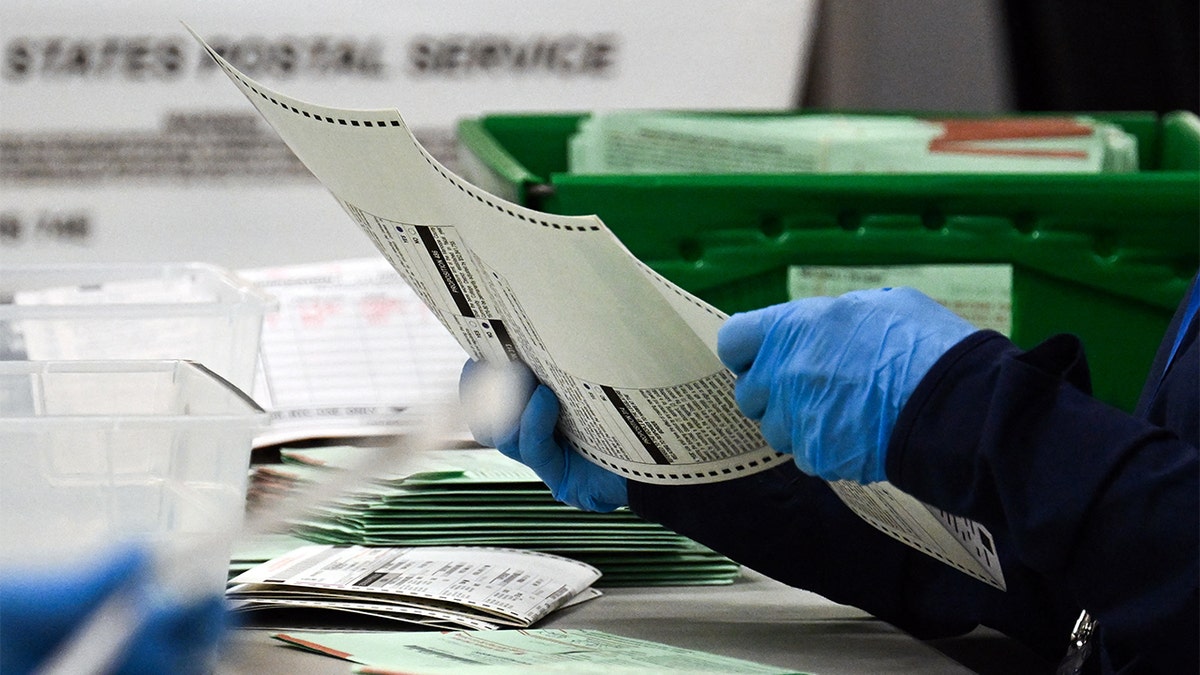 An election worker tabulating a ballot.