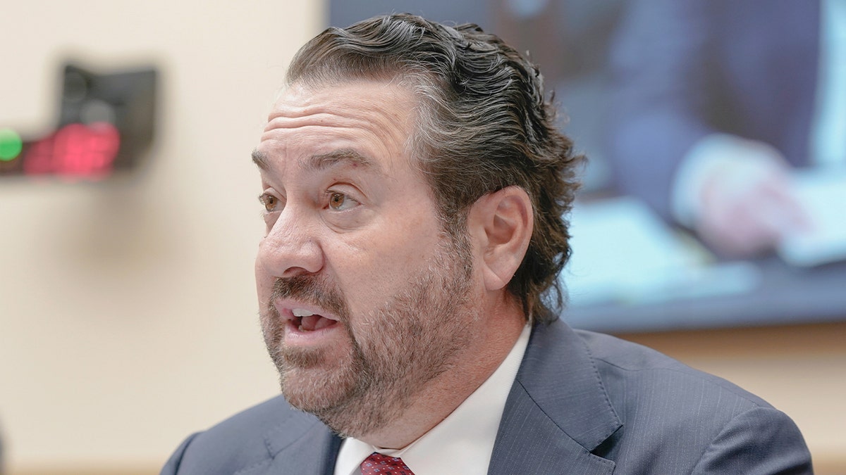 A former state attorney general speaks into a microphone during a congressional hearing in Washington.