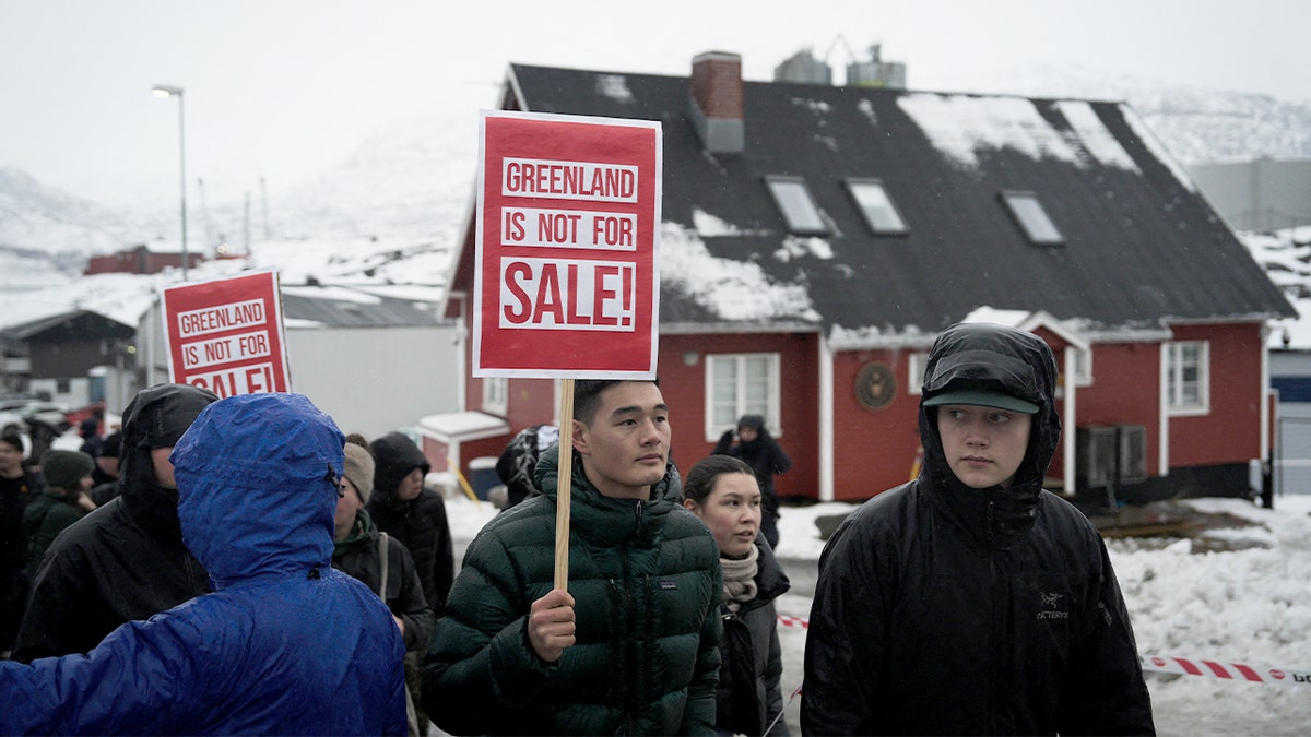 Young demonstrators hold protest signs outside the U.S. Consulate in Nuuk to oppose foreign control of Greenland.