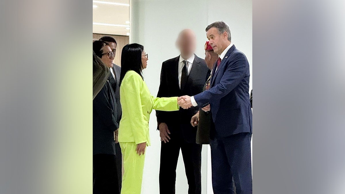 Delcy Rodriguez shakes John Ratcliffe's hand