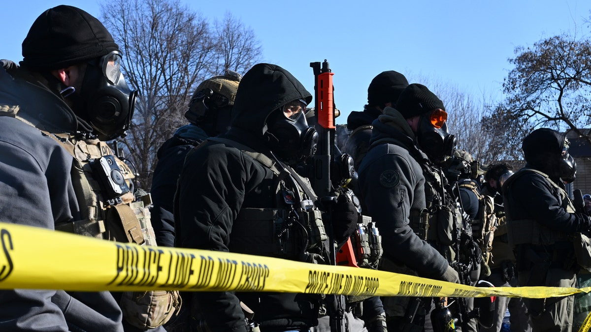 Federal agents behind a police line