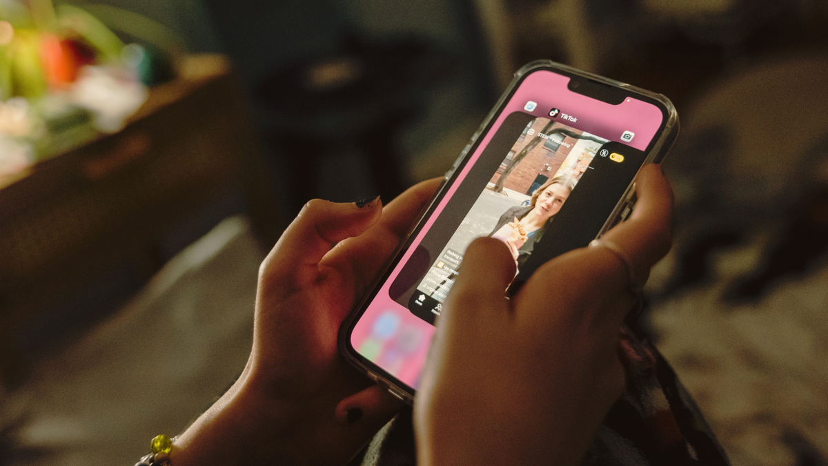 A teenager uses social media on her phone in her bedroom in New York City.