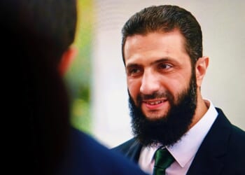 Syrian president Ahmed al-Shara smiling.