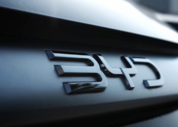 Close-up of a metallic 'BYD' emblem on the dark rear of a modern car
