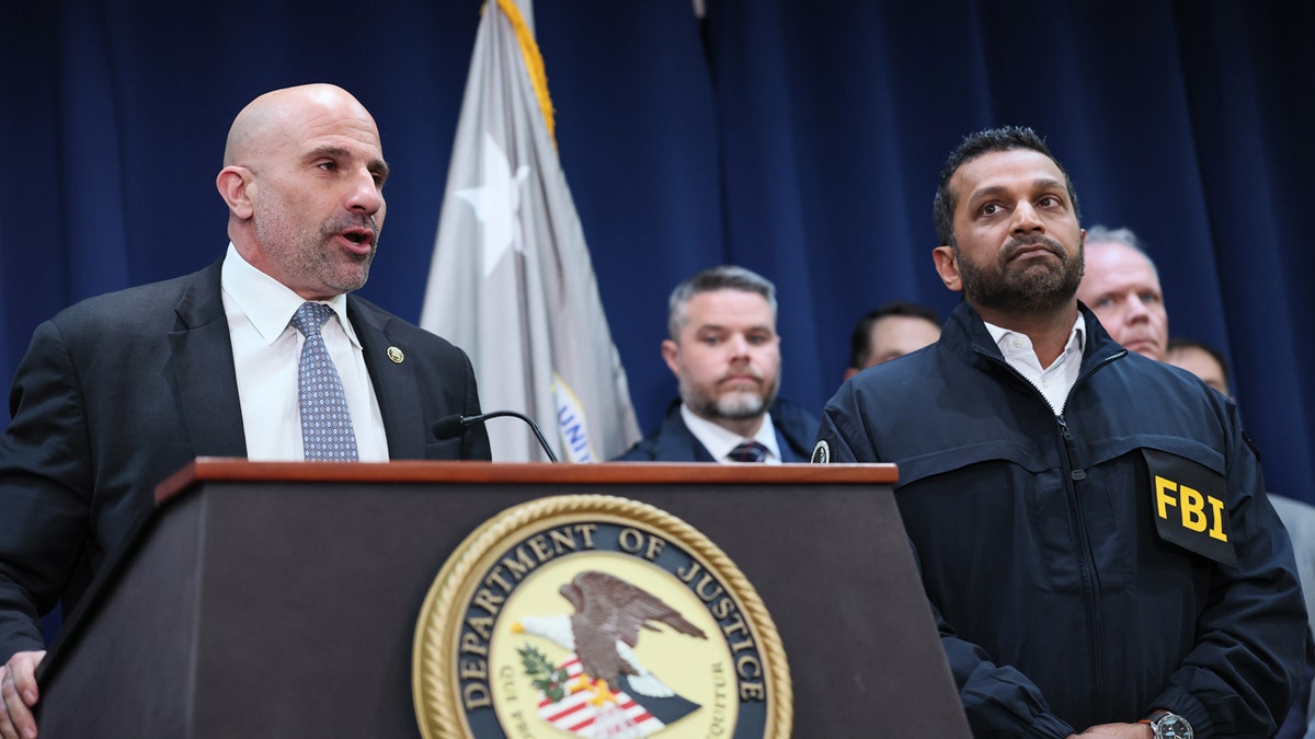 Christopher Raia stands next to FBI Director Kash Patel at a press conference