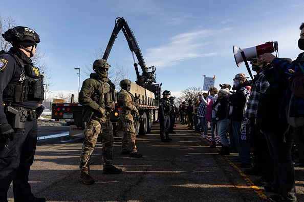Federal agents and protestors outside an ICE facility during a protest