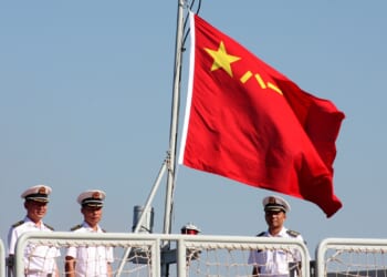 Chinese sailors under a People's Liberation Army Navy flag.