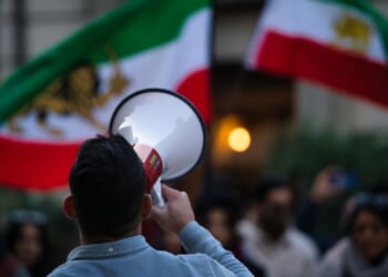 Iranian anti-Islamic Republic protests with Pahlavi flag.