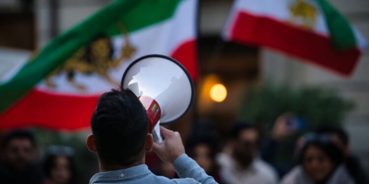 Iranian anti-Islamic Republic protests with Pahlavi flag.