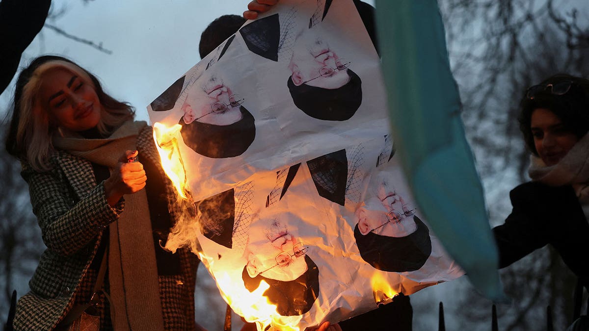 Demonstrators burn pictures of Iran's Supreme Leader Ayatollah Ali Khamenei outside the Iranian embassy during a rally in support of nationwide protests in Iran, in London, Jan. 12, 2026. 