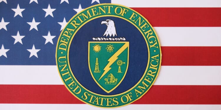 US Department of Energy seal on United States of America flag close up. Office of Fusion