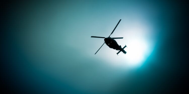Military navy helicopter flying at night on the moon background.