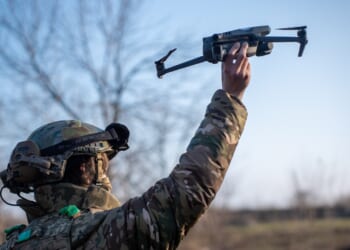 A Ukrainian soldier carrying a drone.