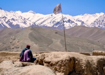 Man sits on ruin in Taliban's Afghanistan.