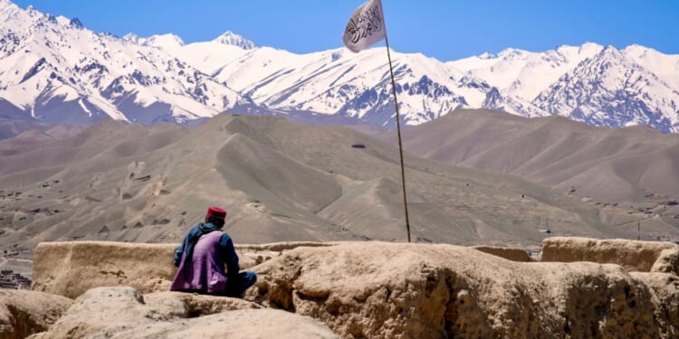 Man sits on ruin in Taliban's Afghanistan.