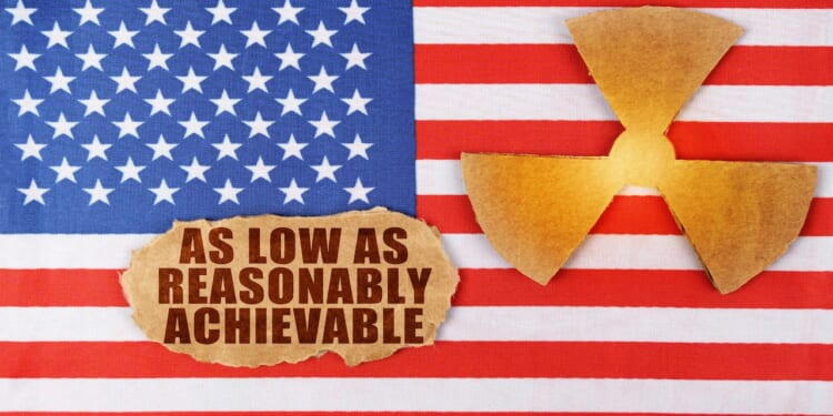 Industry and radiation concept. On the flag of the United States, there is a symbol of radioactivity and a torn cardboard with the inscription - As Low As Reasonably Achievable ALARA