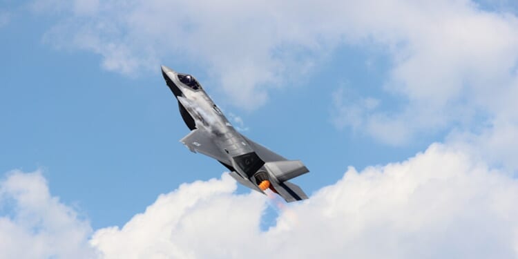 An F-35 ascending in the sky.