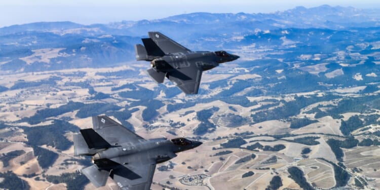 F-35s zoom over desert environment.