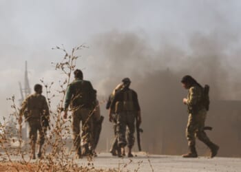 Fighters in Syria after a bombing.