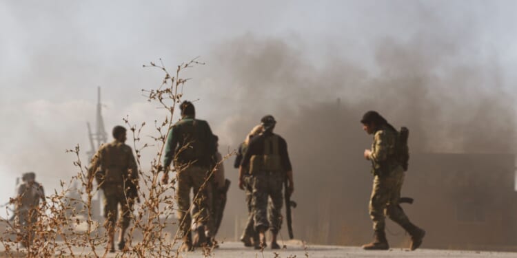 Fighters in Syria after a bombing.