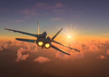 An F/A-18 Hornet in flight at dusk.