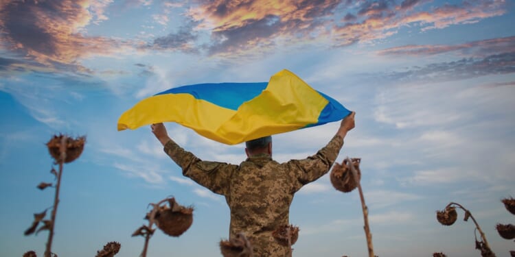A Ukrainian soldier carrying a flag.