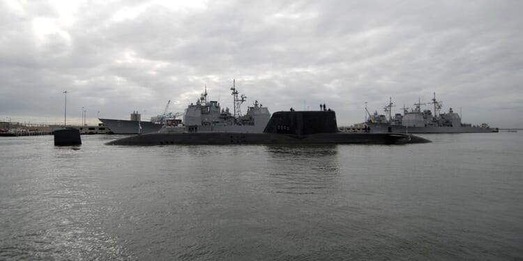 An Astute-class submarine near a naval yard.